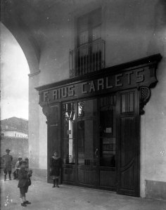 Vista general de la façana de la botiga de Papers Carlets, a Olot, 1914 (ACGAX. Fons Sadurní Brunet Pi. Autor: Sadurní Brunet. Codi atribuït 29.4.3)